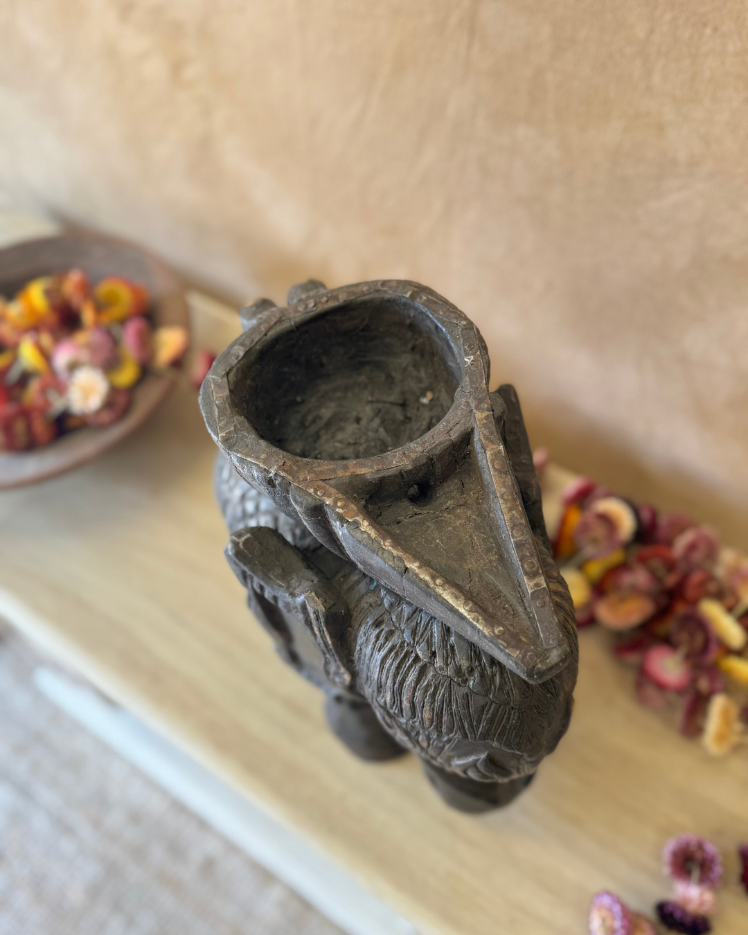 Maceta vintage con forma de elefante tallada a mano, acabado oscuro y asa con figura invertida. 