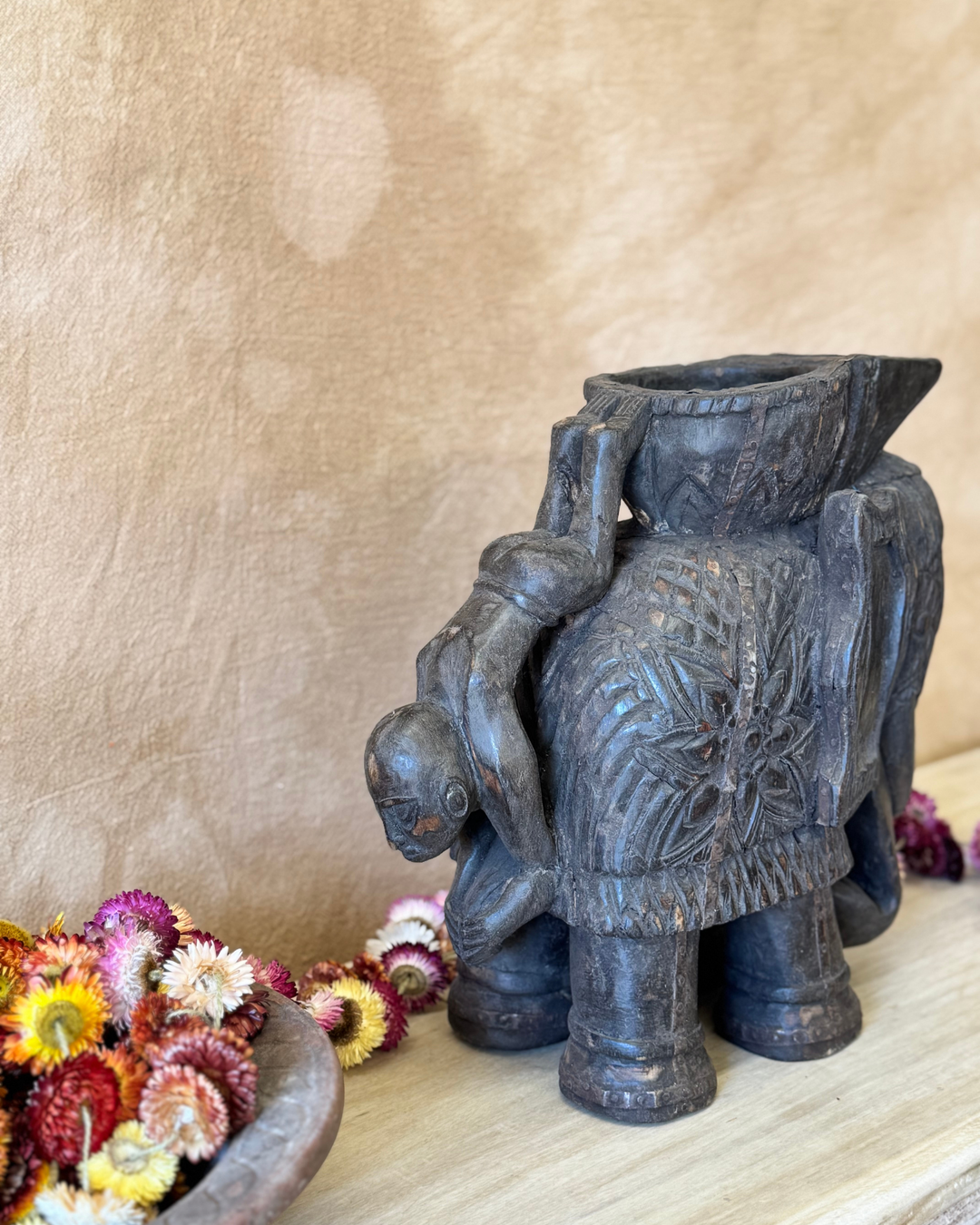 Maceta vintage con forma de elefante tallada a mano, acabado oscuro y asa con figura invertida. 