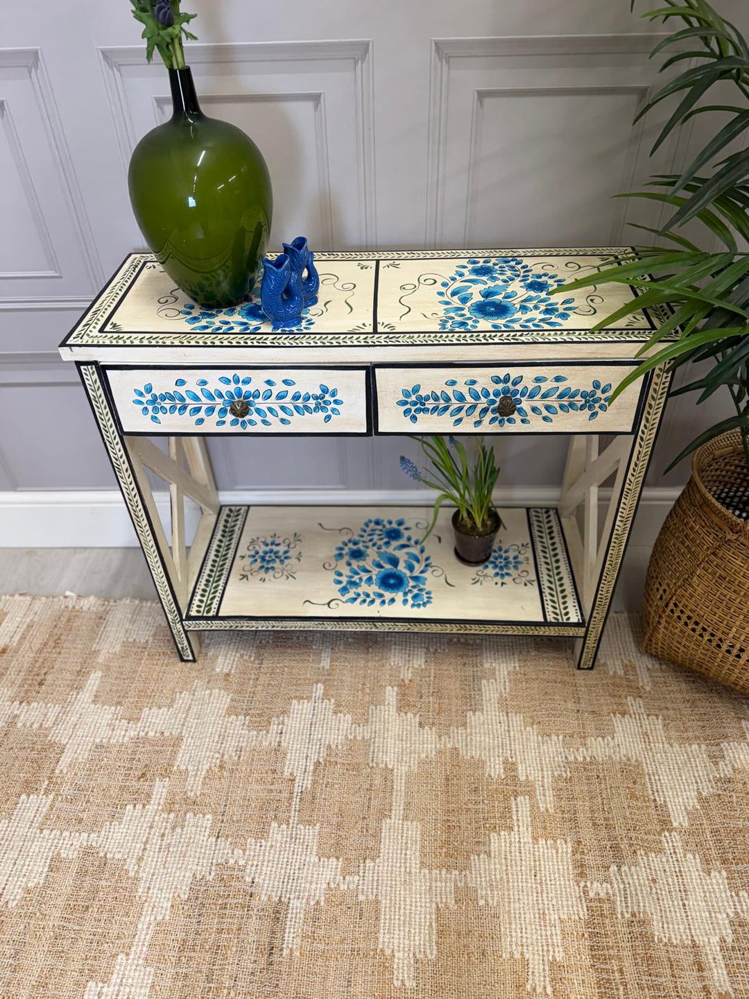 Consola pintada a mano, acabado crema con detalles florales en turquesa y dos cajones.