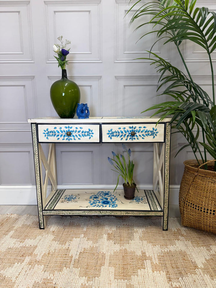 Consola pintada a mano, acabado crema con detalles florales en turquesa y dos cajones.